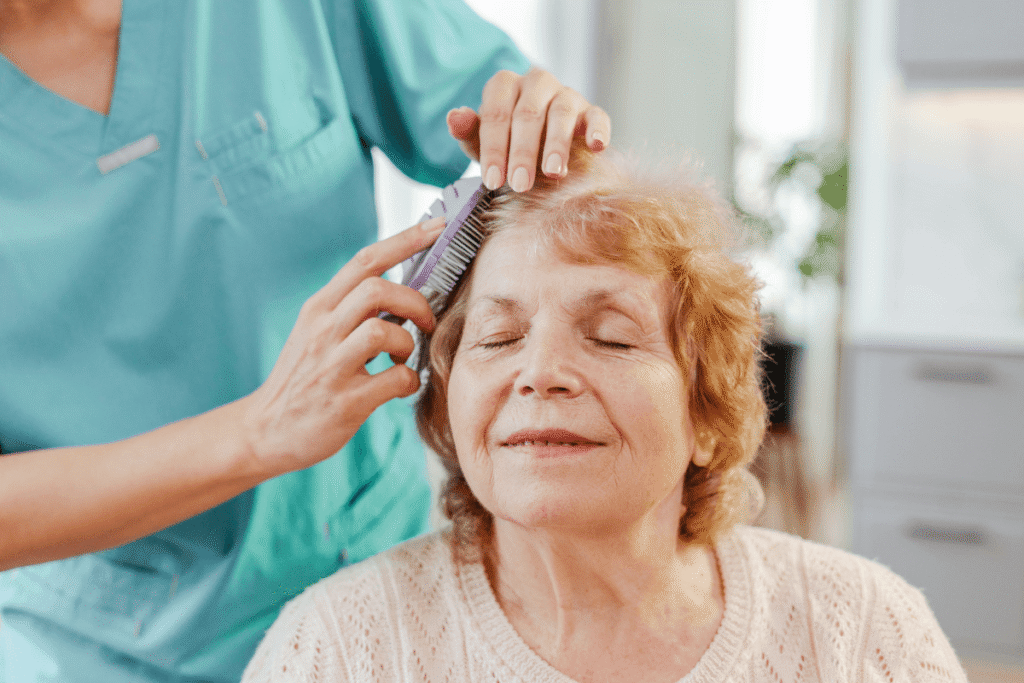 Smiling nurse brushing a senior woman's hair, showing care and compassion in a heartwarming moment of trust and support.